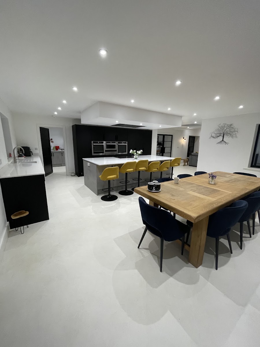 A seamless microcement floor flowing through a large open-plan kitchen-diner